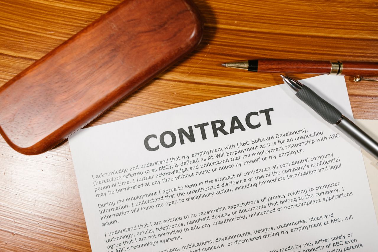 journey A close-up view of a contract and pen on a wooden desk, ideal for business themes.