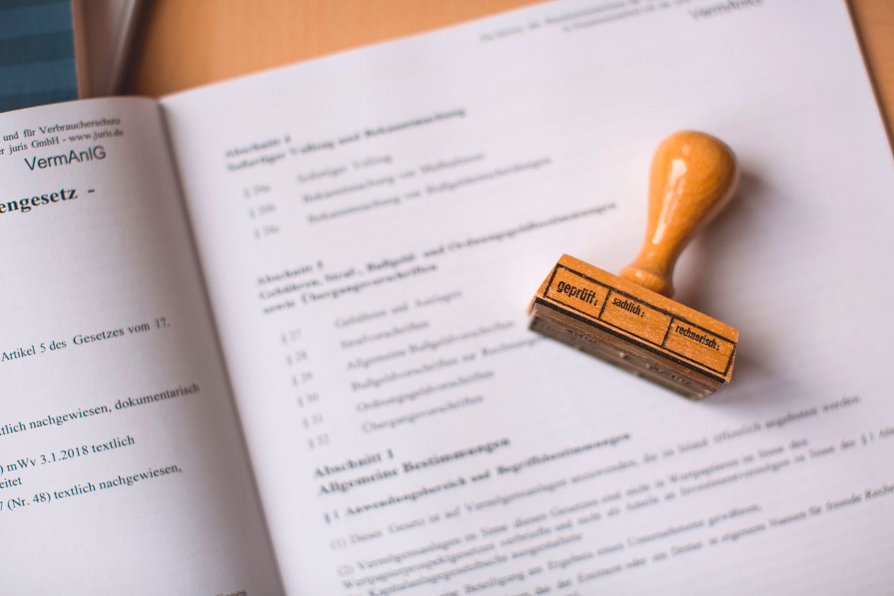 team-02 Close-up of a legal document with a wooden stamp placed on top, highlighting verification.